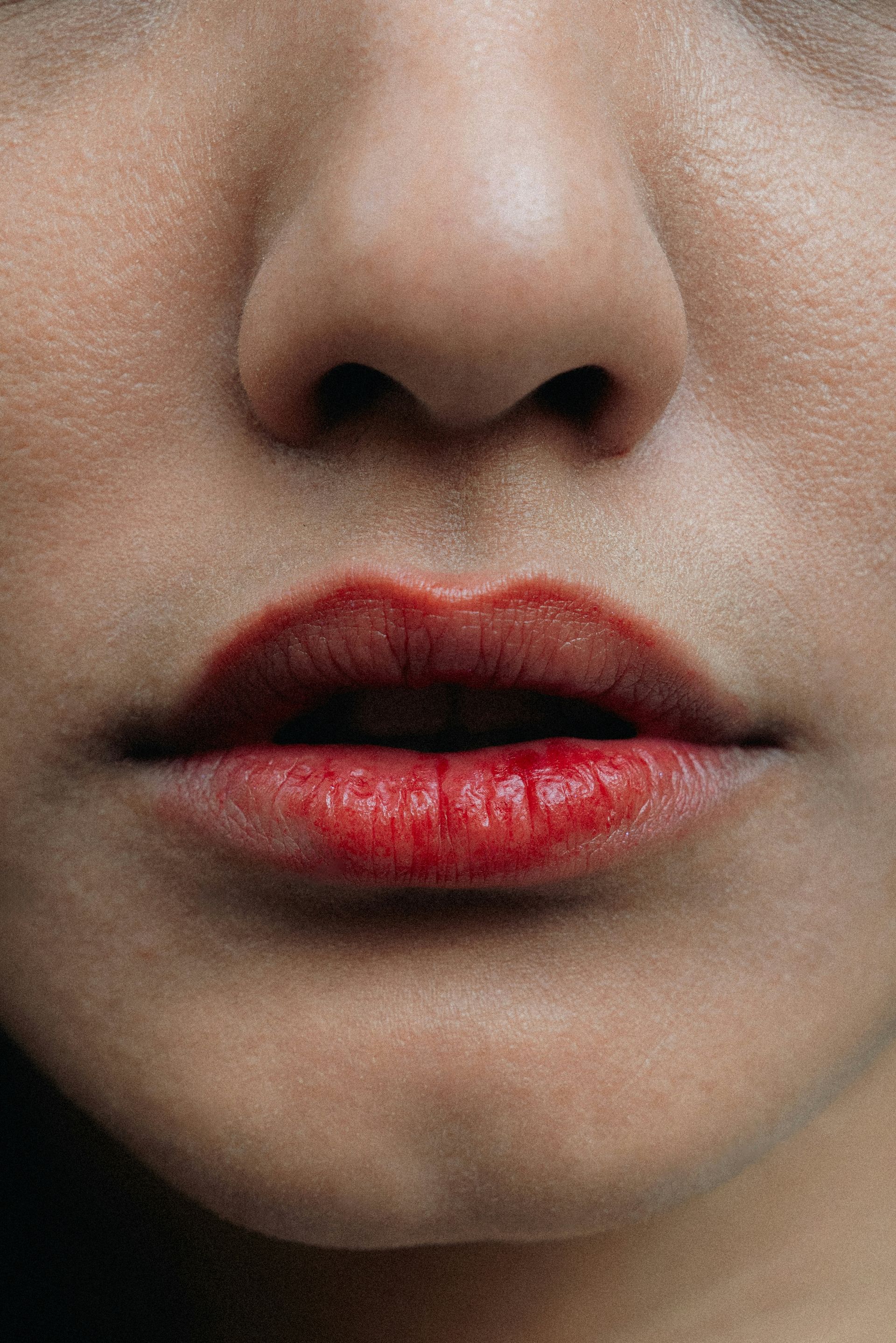 Close-up of a woman's red lips and nose